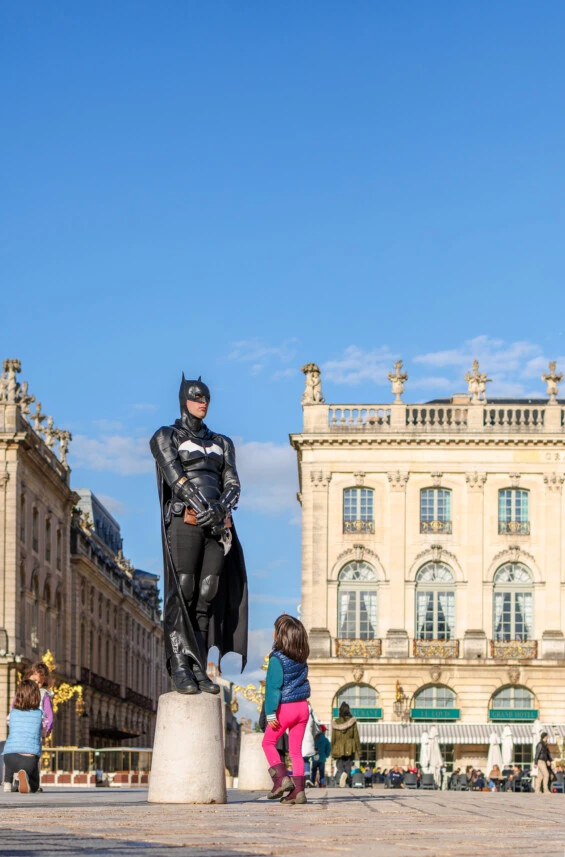 Un homme avec un costume de Batman pose sur la Place Stanislas